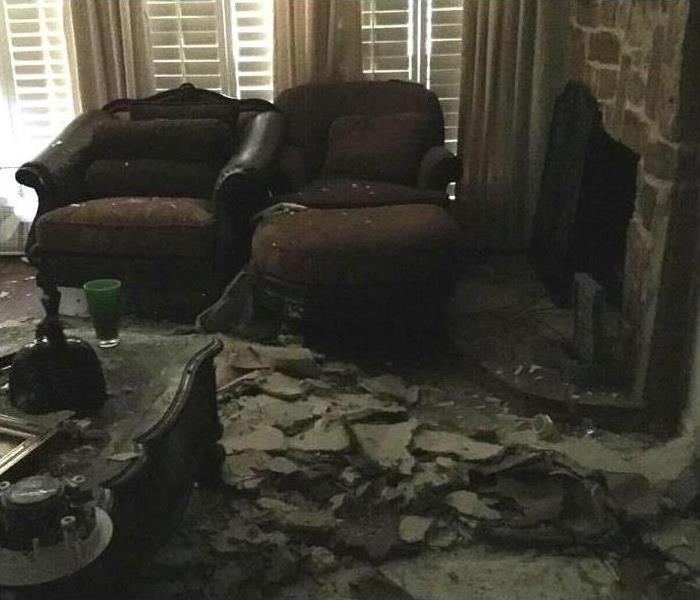 furniture covered in rubble from a collapsed ceiling caused by a burst water heater