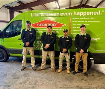 Four male technicians standing in front of SRVPRO van